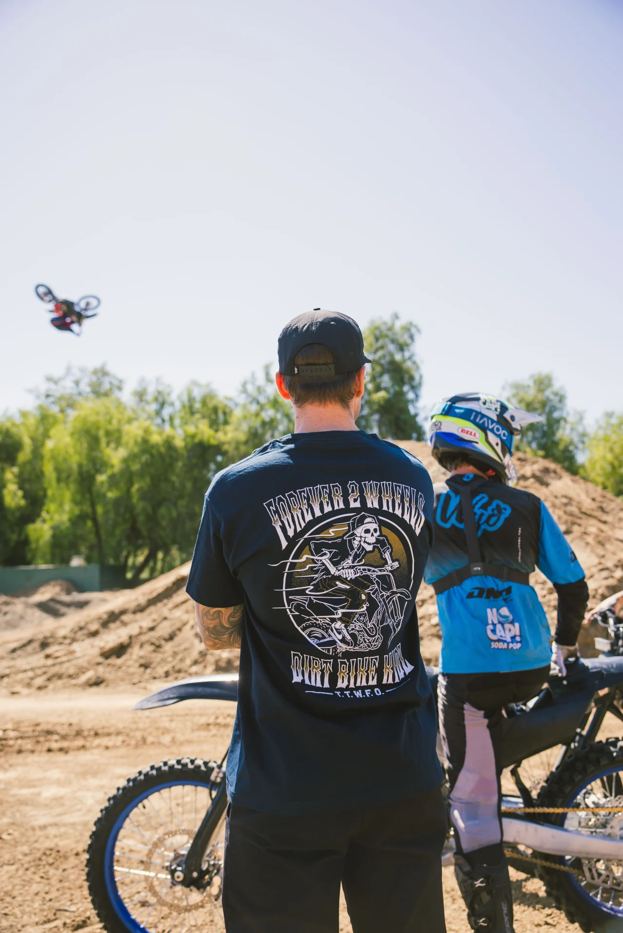 DBK Ghost Rider Tee in navy worn beside a dirt bike, back view