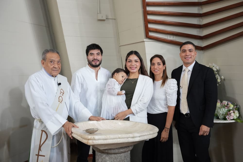 Fotografía de bautizo en Lima: la familia y el sacerdote junto a la pila bautismal