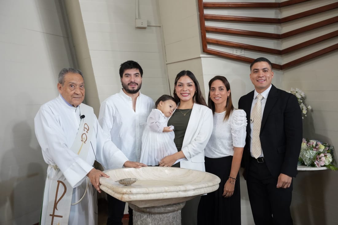 Fotografía de bautizo en Lima: la familia y el sacerdote junto a la pila bautismal