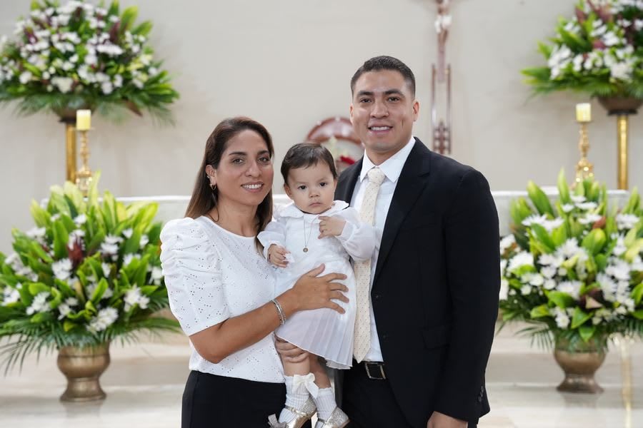 Fotografía de bautizo en Lima: papá y mamá con su bebé en la iglesia