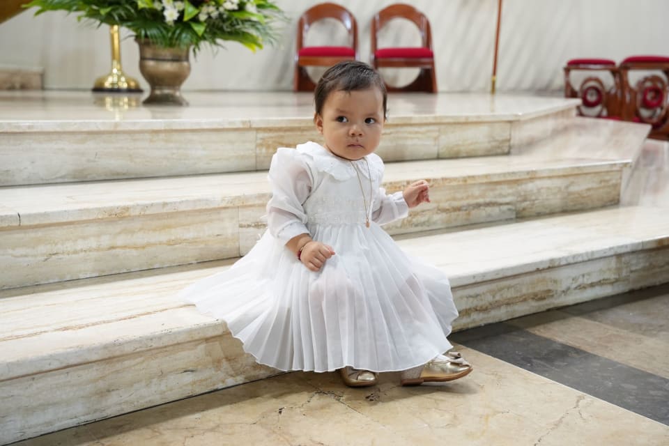 Fotografía de bautizo en Lima: Zoe con vestido blanco en las escaleras de la iglesia