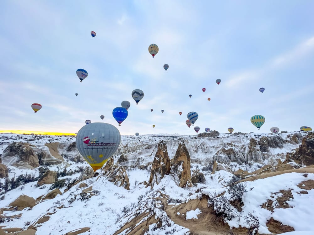 Hot air balloons flying over Love Valley at sunrise in Cappadocia Turkey