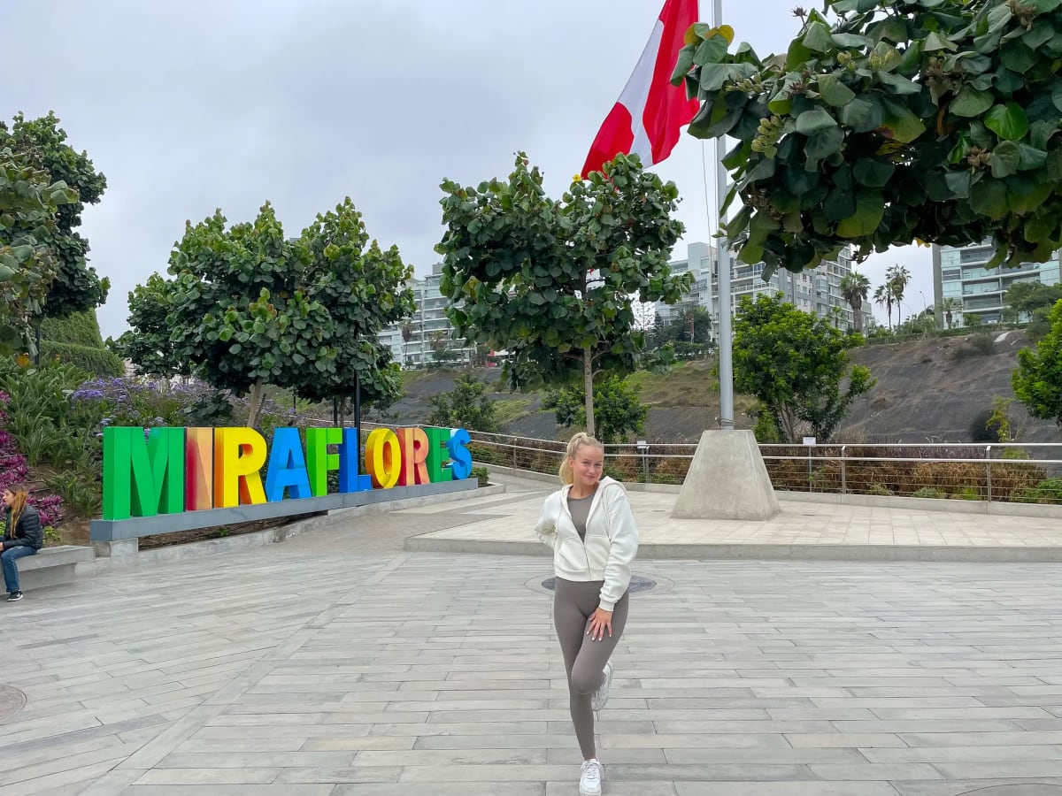 Girl in front of a Miraflores sign along the Malecón de Miraflores in Lima, Peru