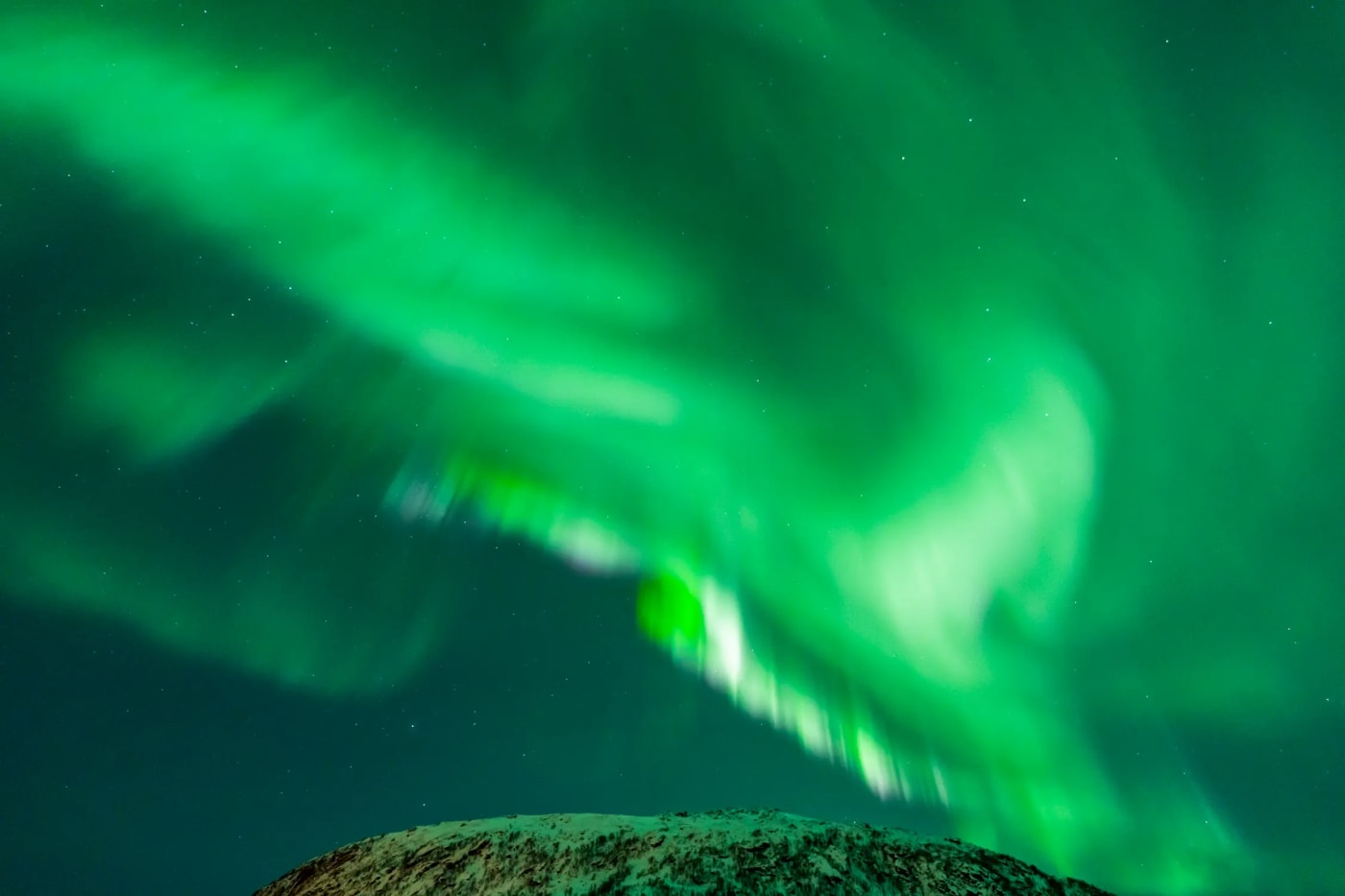 Northern lights (aurora borealis) over the snowy mountains of Tromsø Norway in the winter