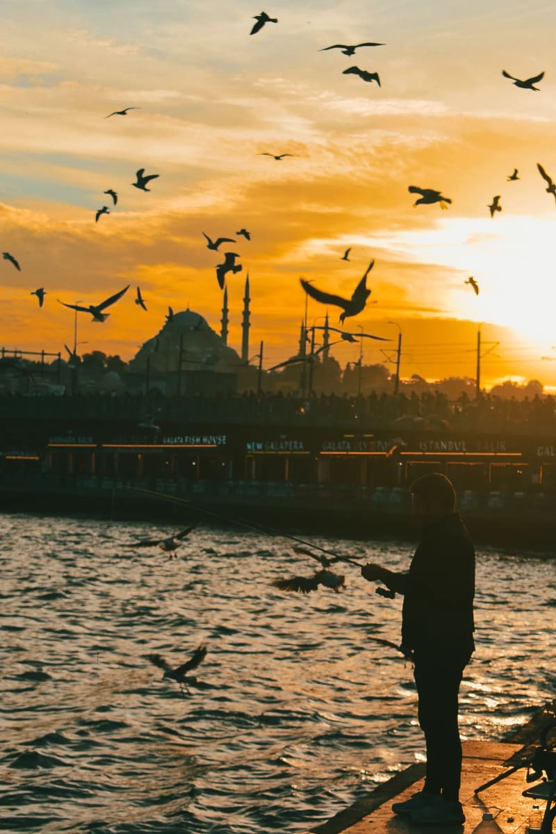 Fishermen at sunset on the Galataport promenade Istanbul, Turkey