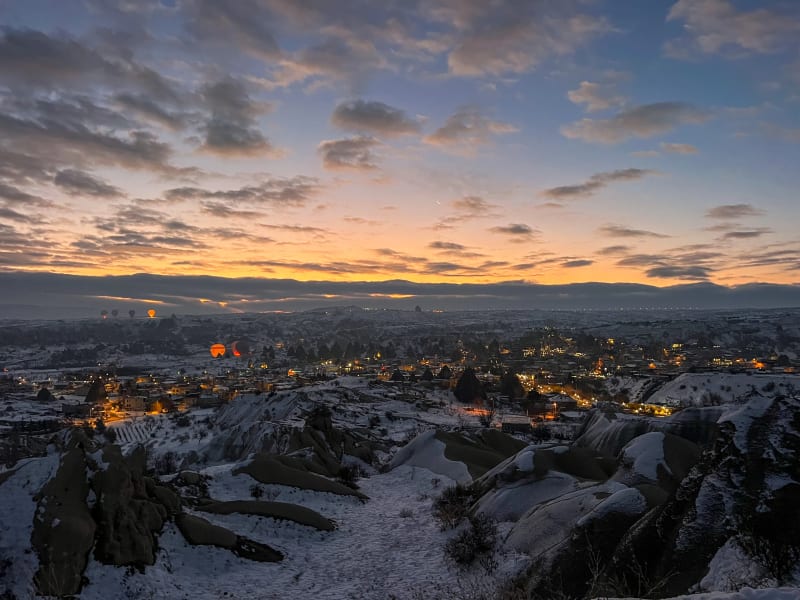 Hot air balloon taking off at sunrise from a viewpoint in Göreme in Cappadocia Turkey