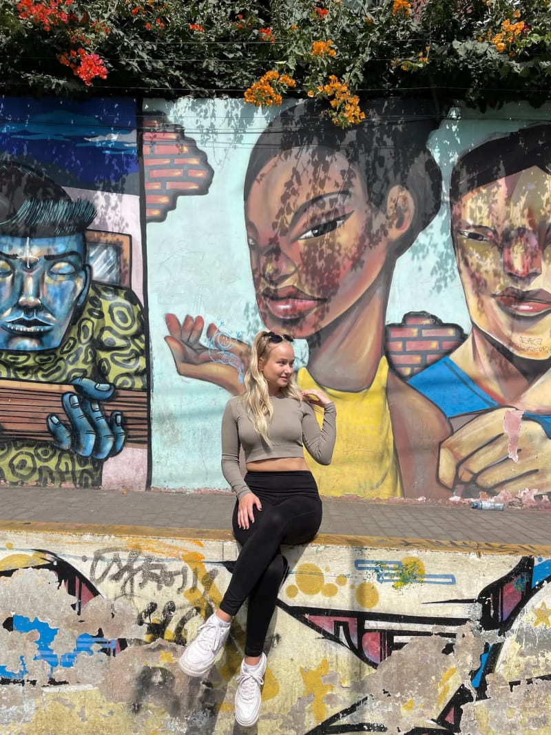 Girl in front of the graffiti street art in Barranco in Lima, Peru