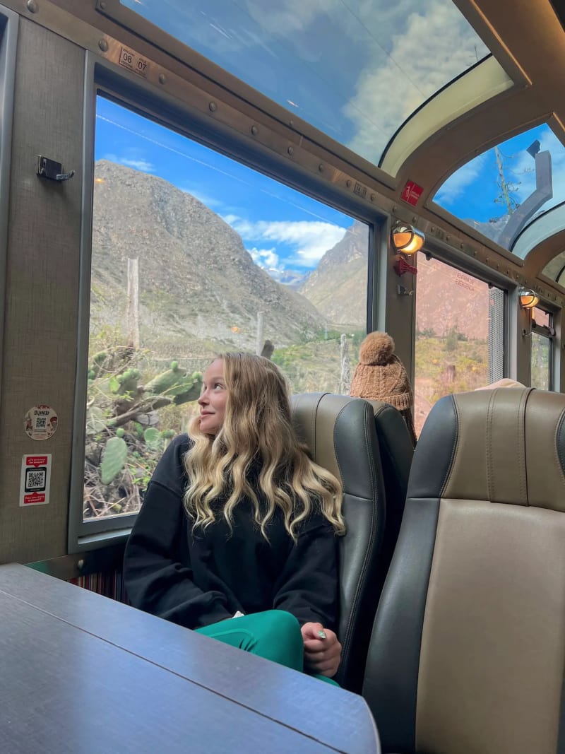 Girl looking out the window on IncaRail train car for Machu Picchu in Peru