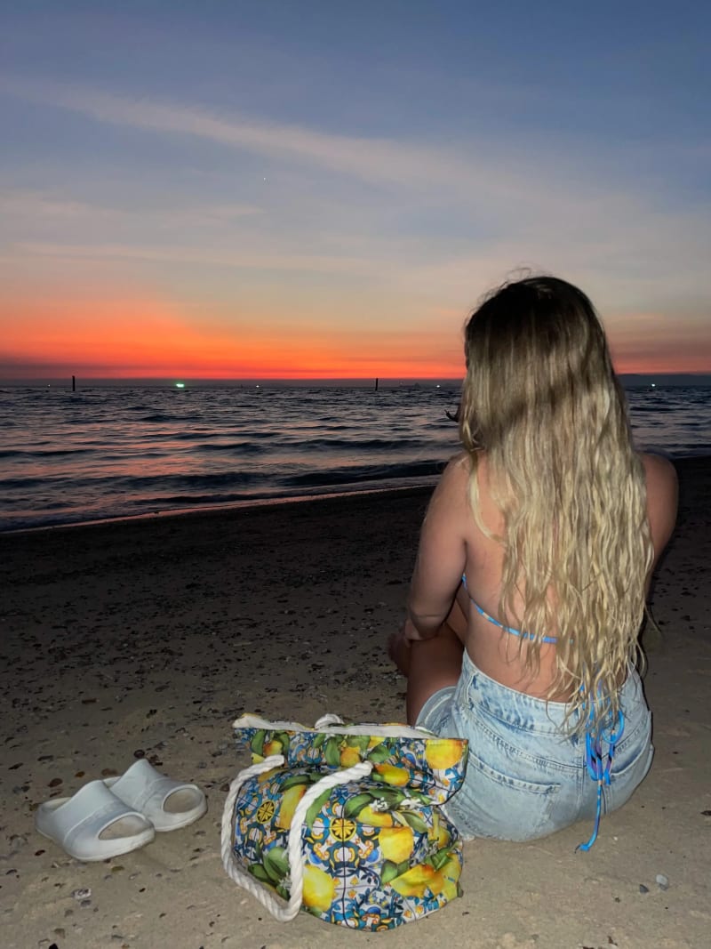 A girl in front of a beach sunset on an island in Thailand