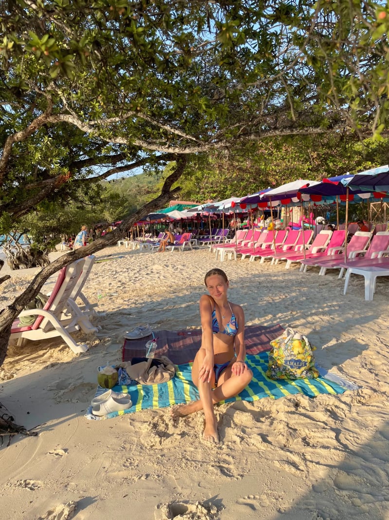 Girl sitting on the sand on a tropical island on Koh Larn Island in Pattaya, Thailand