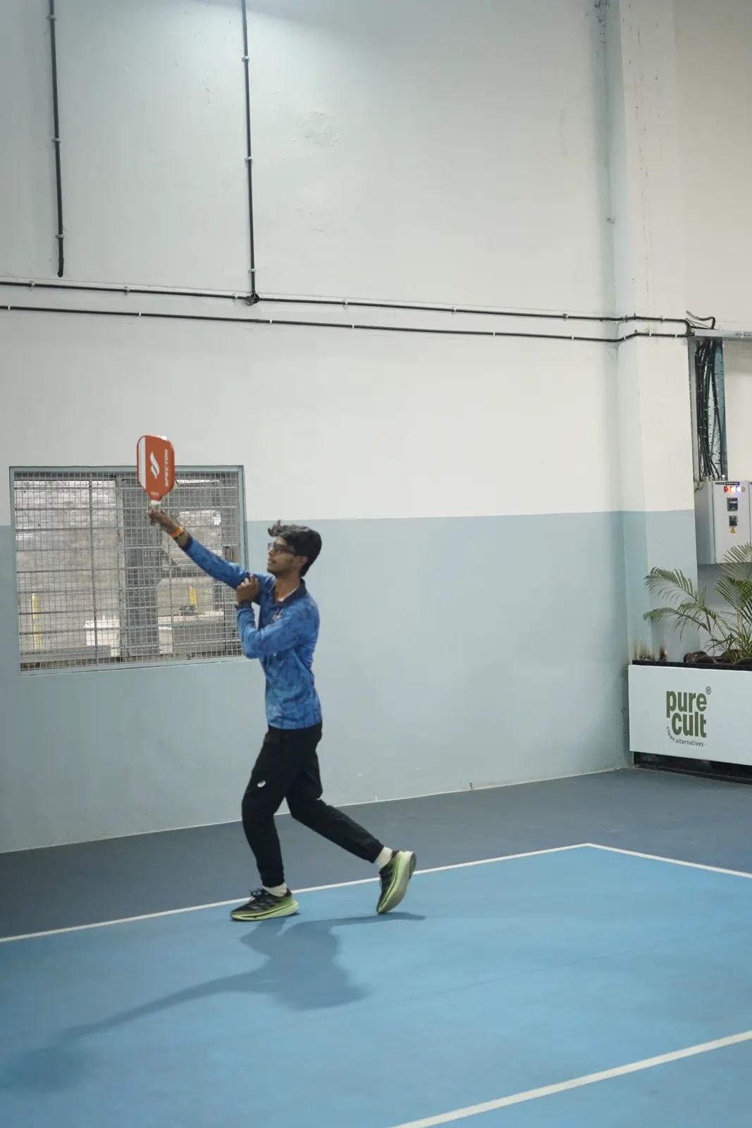 A player follows through on an indoor court at a FindYourFit event
