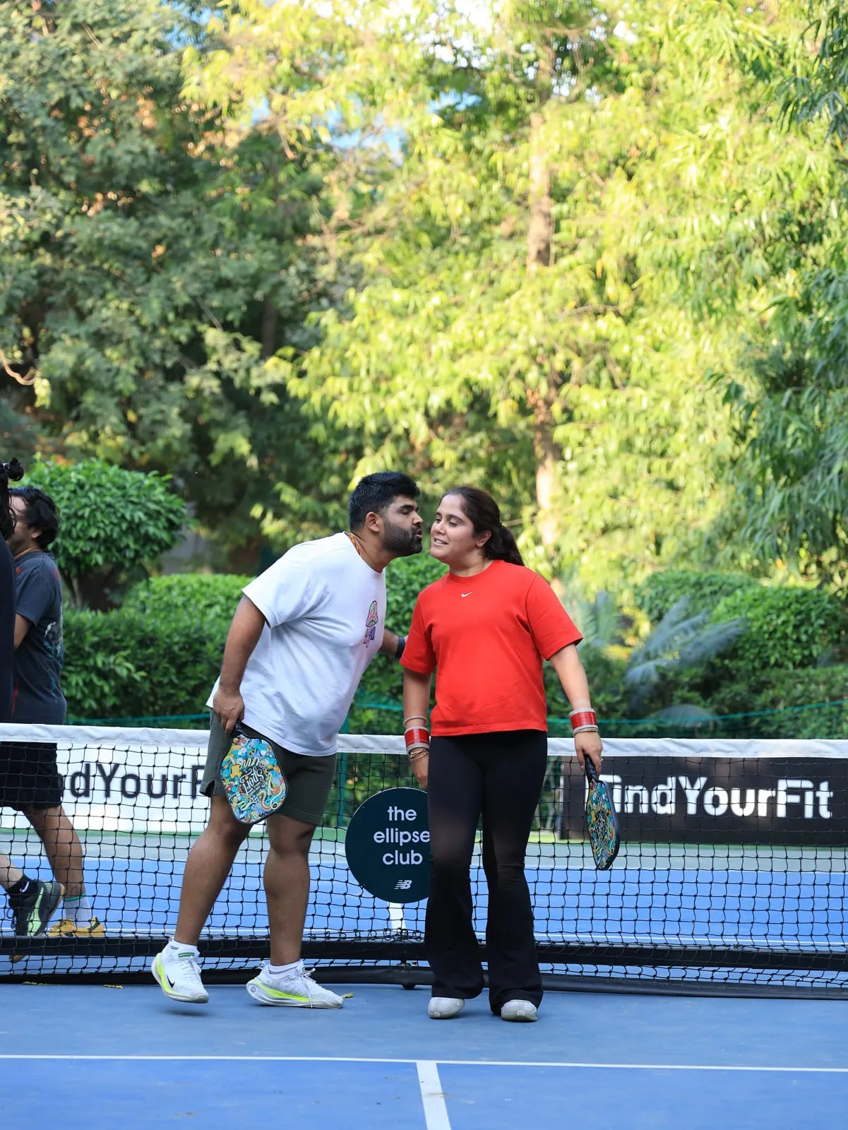 Players meet at the net after a point at a FindYourFit event