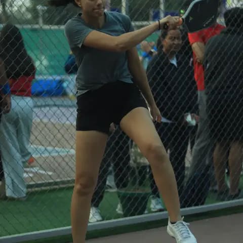 A woman returning a forehand shot at a FindYourFit pickleball night