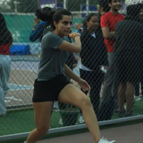 A woman lunging for a pickleball return at a FindYourFit court night