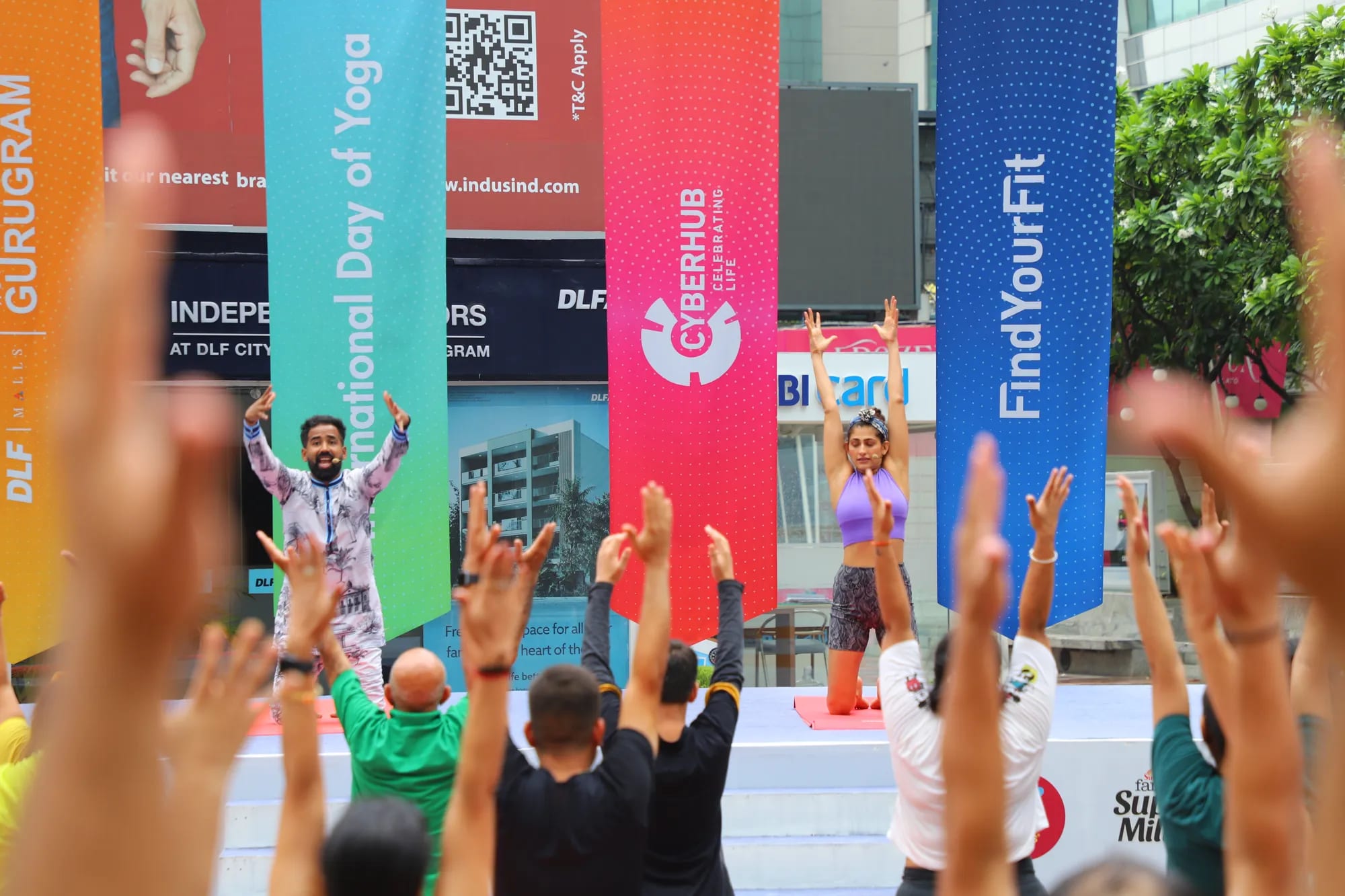 Participants raise their hands during a yoga session at a FindYourFit event
