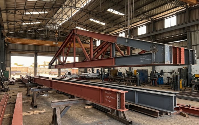 Heavy structural steel beams coated with red oxide rust-inhibitive primer for industrial project in Kenya