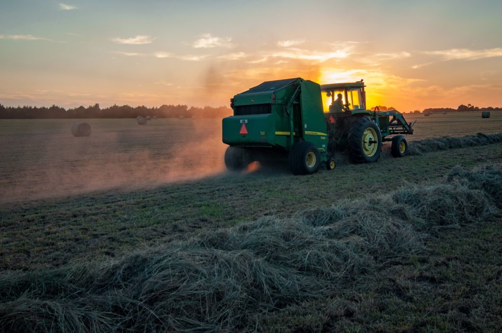 Photo of a tractor working a field at sunset to accompany post about interview with Artem Milinchuk of FarmTogether