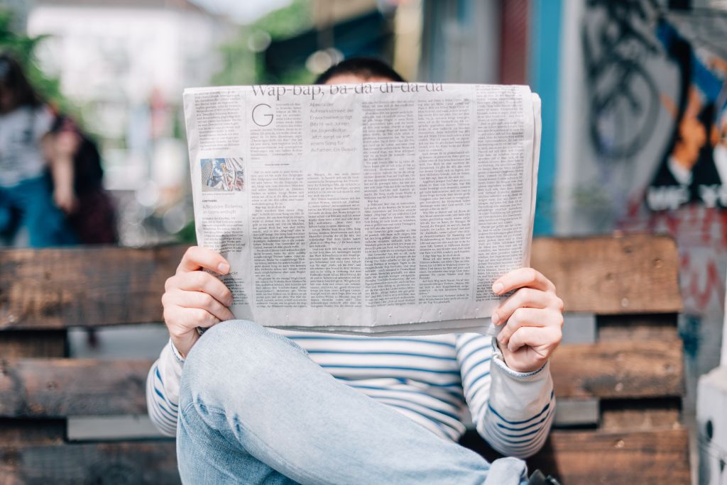 Photo of a man reading a newspaper