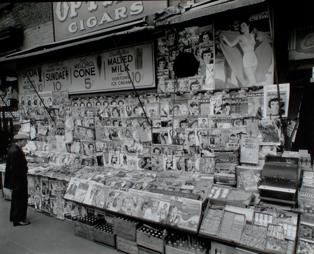 Archival photo from the New York Times of a man browsing an old-timey newsstand