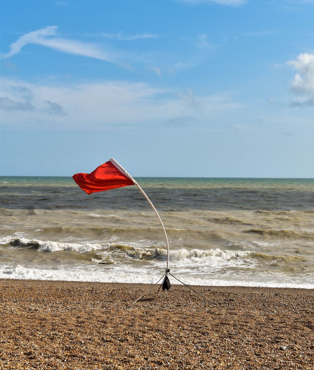 Photo of a red flag on a beach