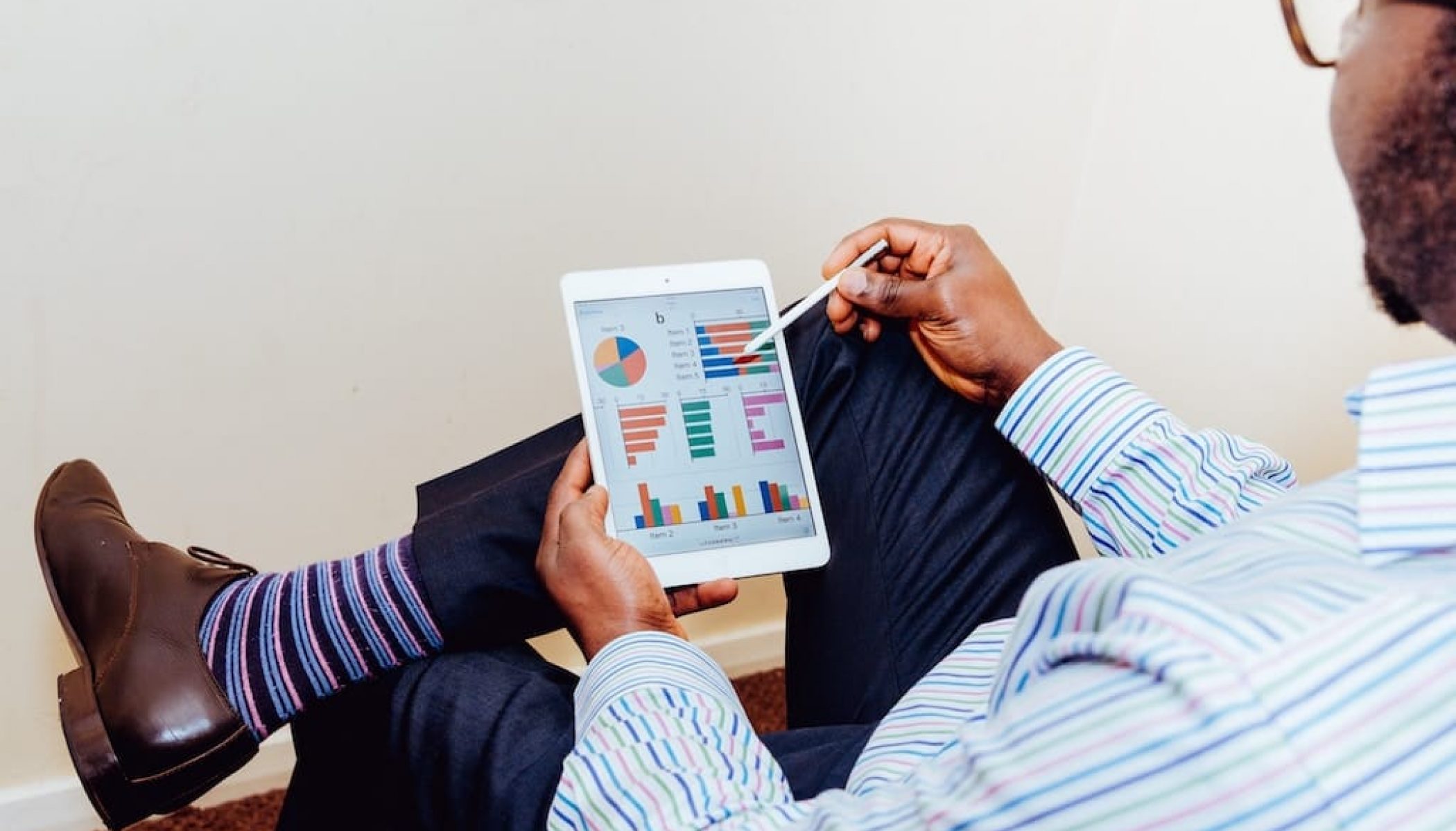 Man reviewing a bunch of random charts on a tablet device