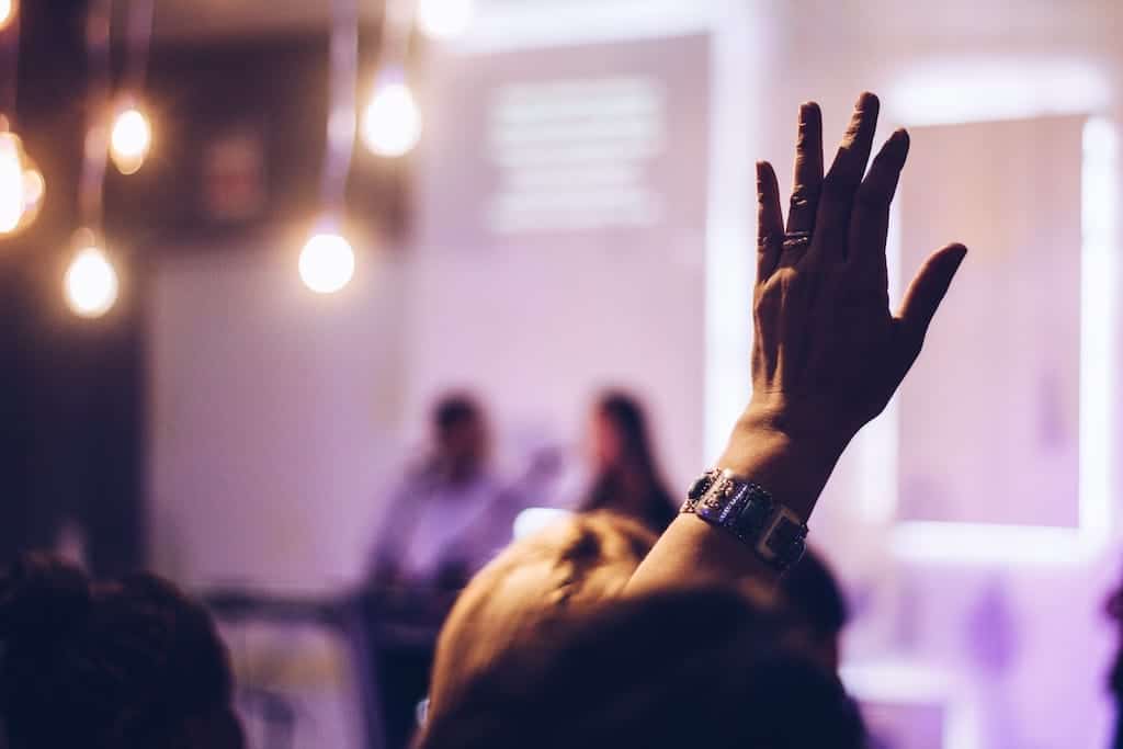 photo of a raised hand from an audience member