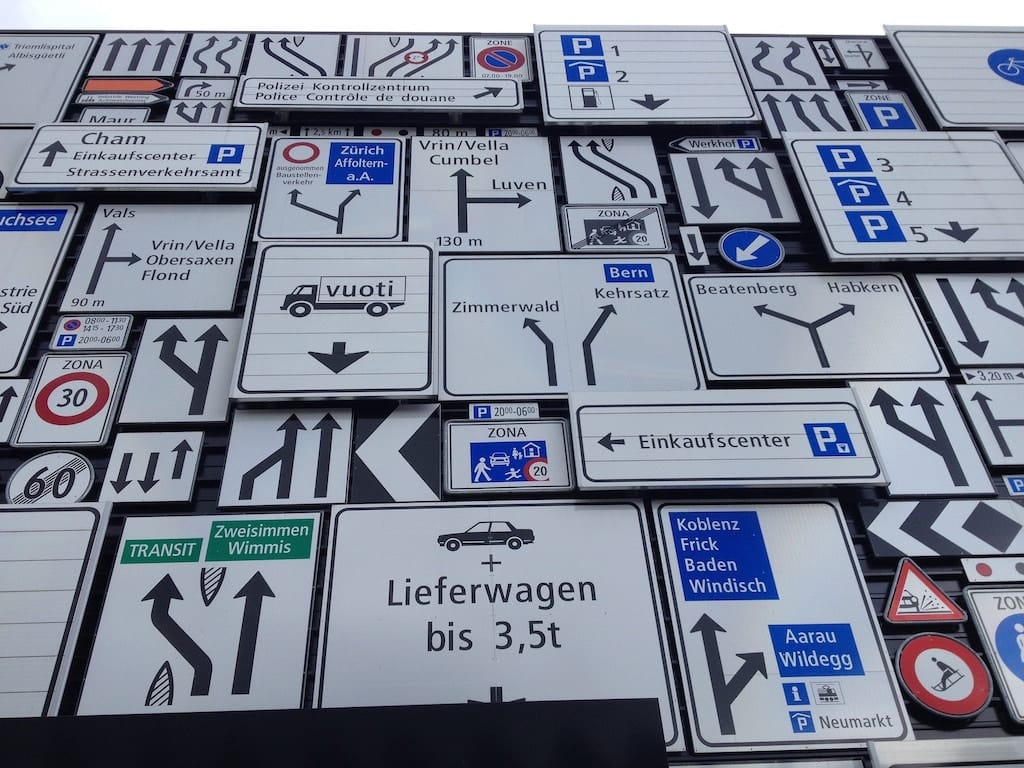 photo of an array of many confusing road signs