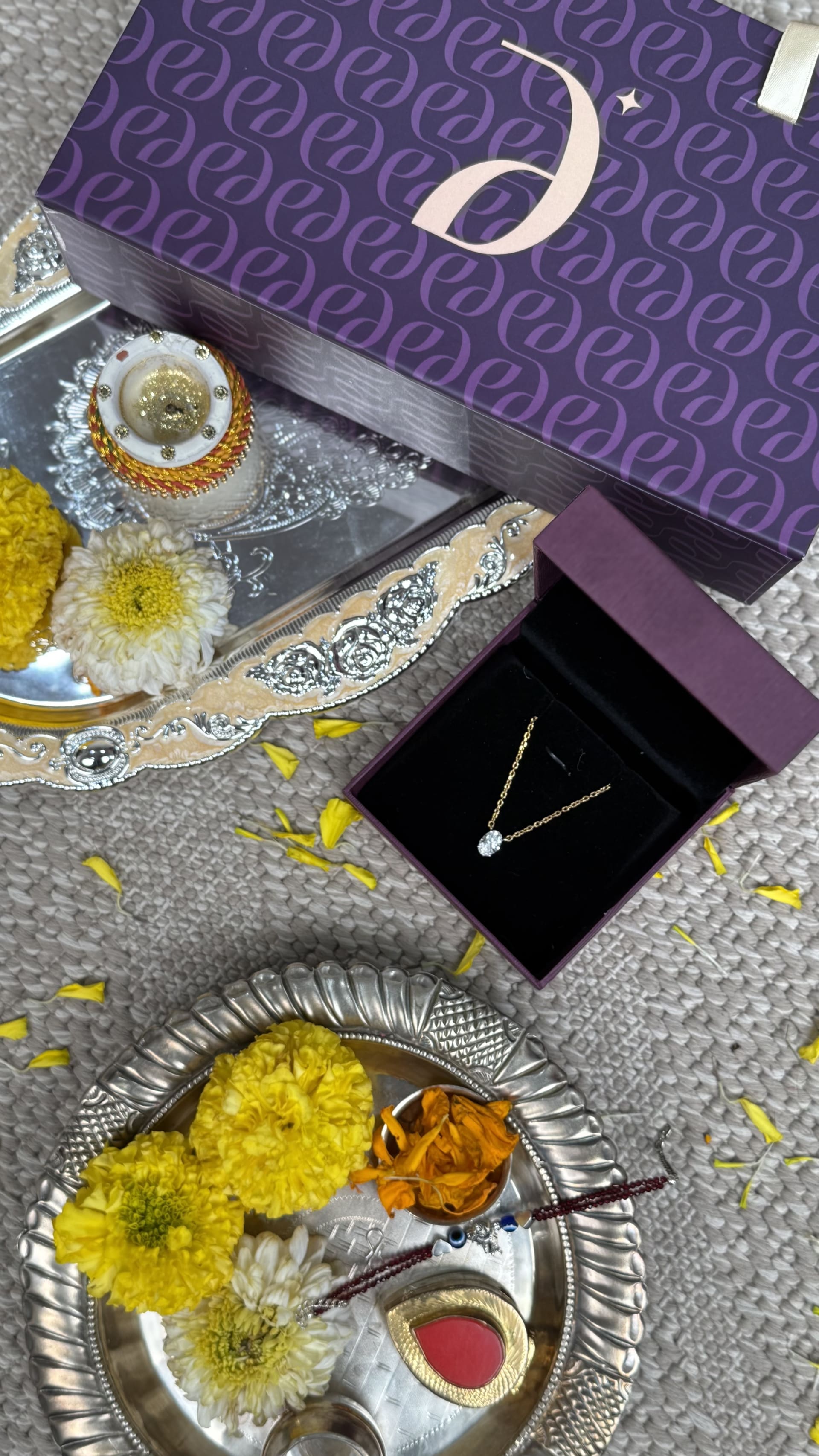 Diava purple gift box with a gold lab grown diamond pendant, festive flat-lay