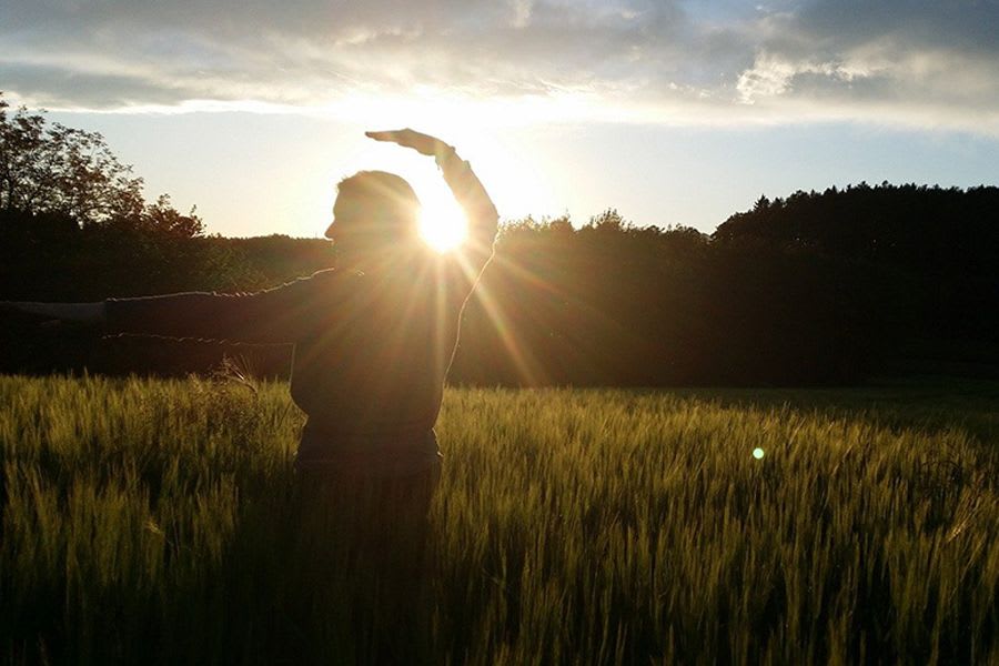 homme pratiquant le Qi gong dans un champs de blé