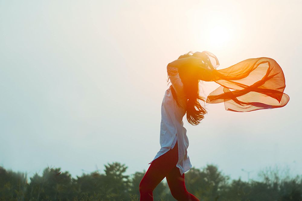 femme libre dans son corps jouant avec un drap orange