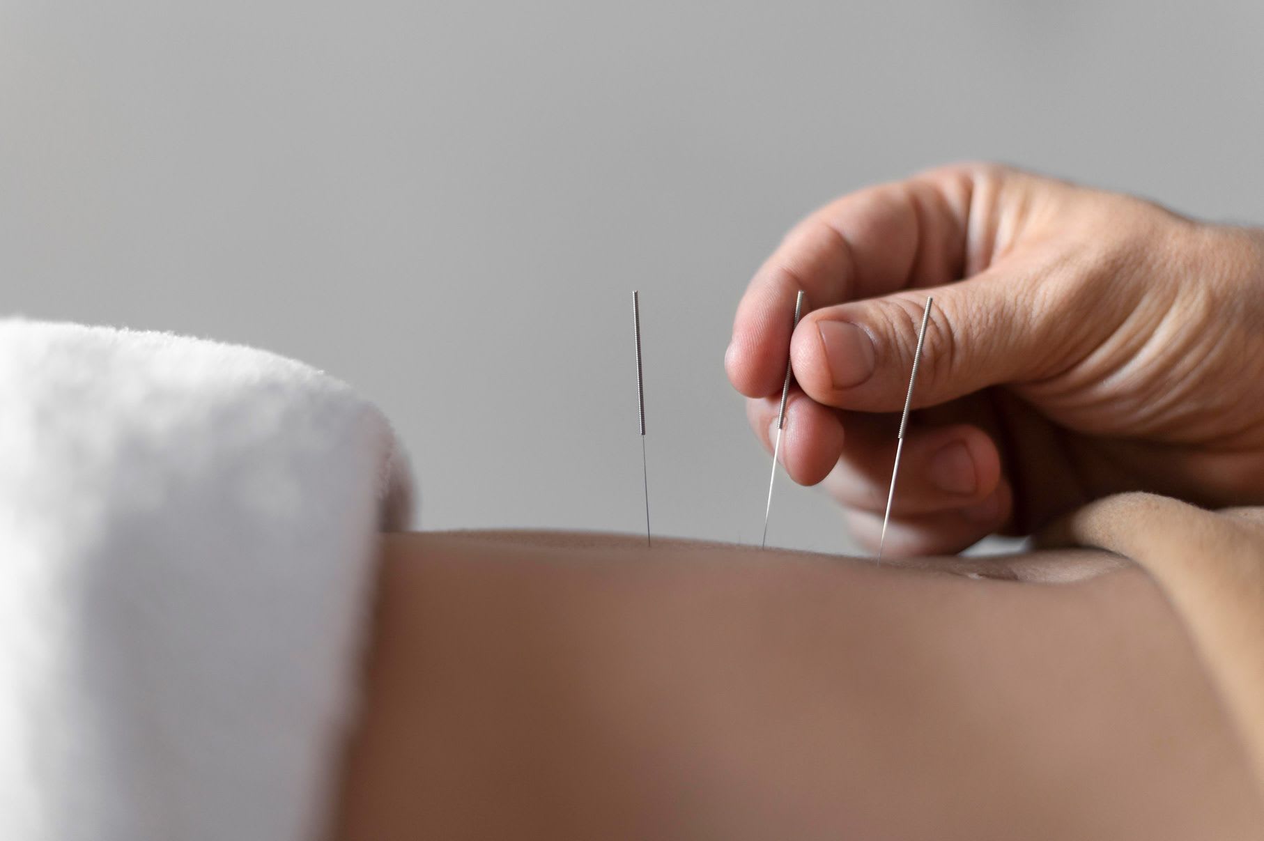 close-up-hand-holding-acupuncture-needle.jpg