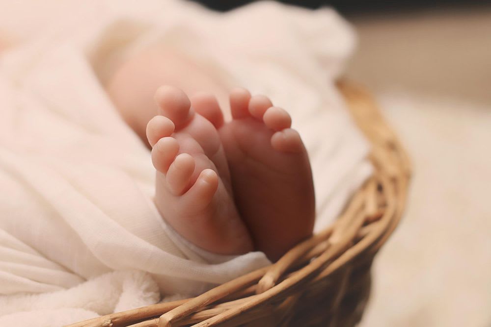 pieds d'un nouveau né dans un panier en osier.