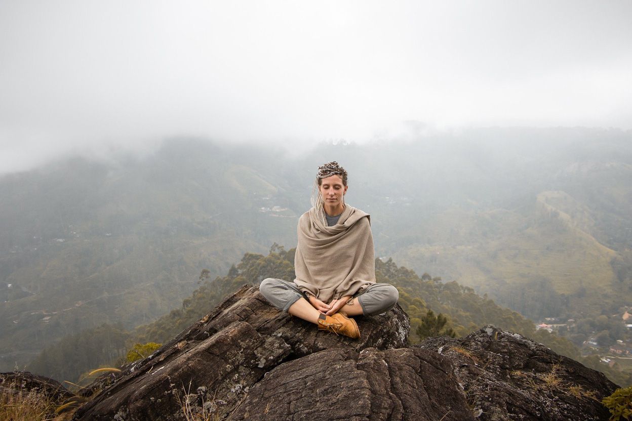 femme qui médite au sommet d'une montagne
