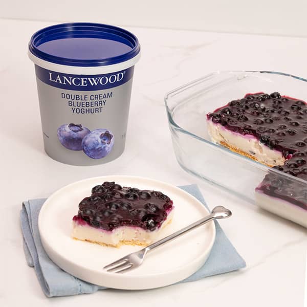 No bake blueberry cheesecake tart made with LANCEWOOD® yoghurt, served on a plate with fresh blueberry topping