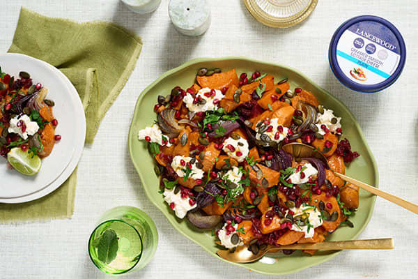 Festive roasted Sweet Potato Salad topped with LANCEWOOD® Cottage Cheese, pumpkin seeds, and cranberries - a protein-rich cottage cheese recipe perfect for the holidays.