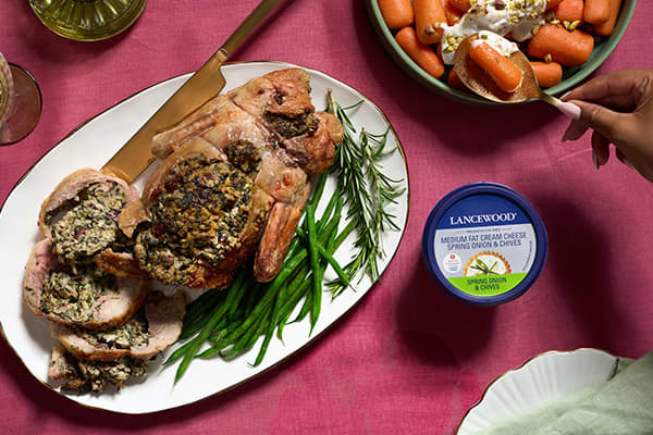 Festive deboned stuffed duck filled with spinach, walnuts, and cranberries, made with LANCEWOOD® Medium Fat Cream Cheese Spring Onion & Chives - an impressive cream cheese recipe for the holidays.
