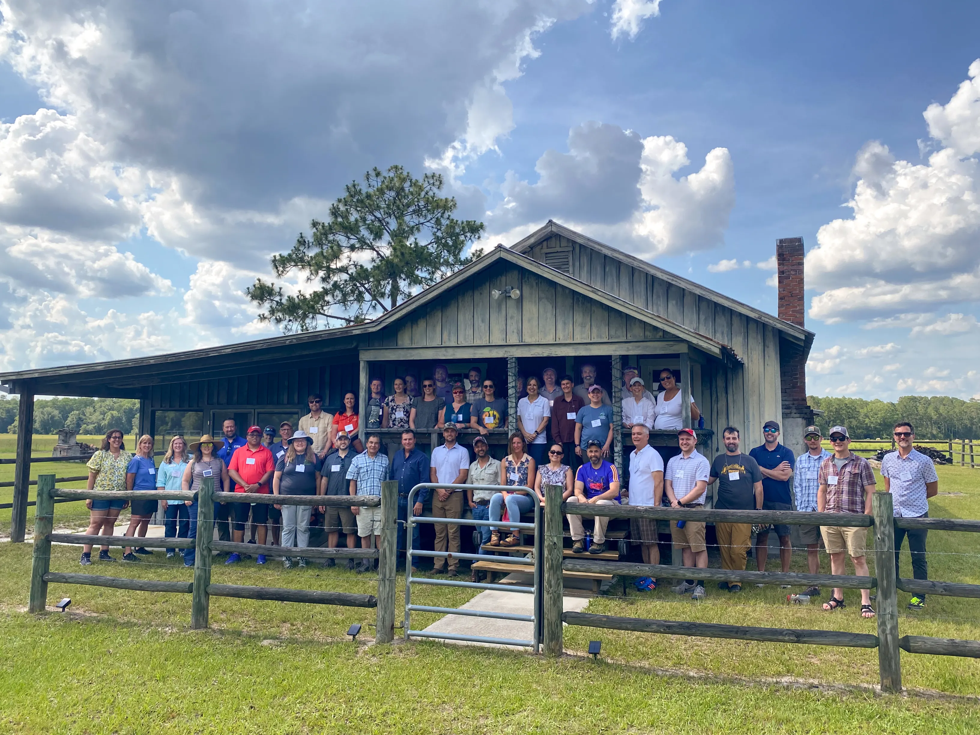 About 70 people standing in front of a small house