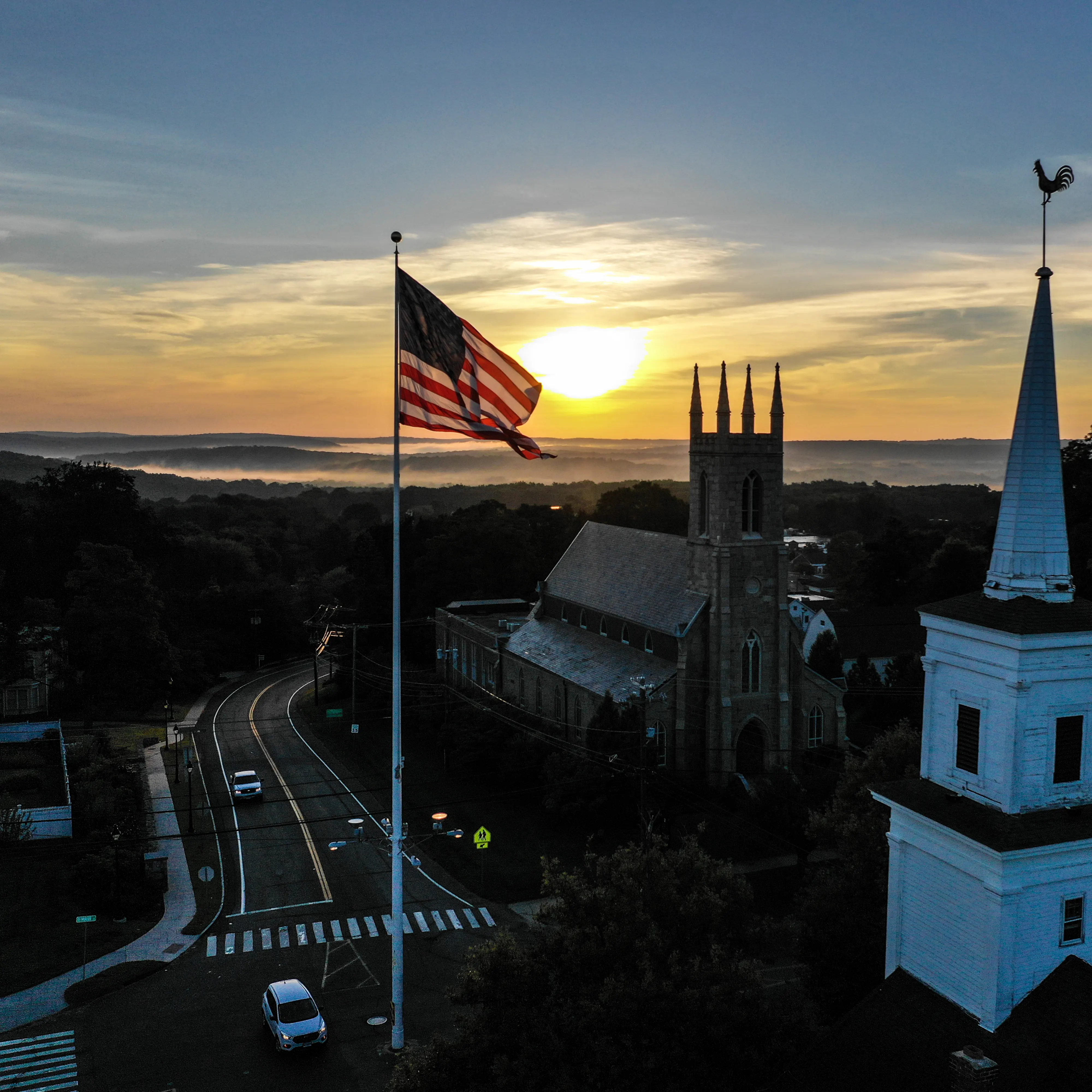 Photo of a town center with a flag in the middle.