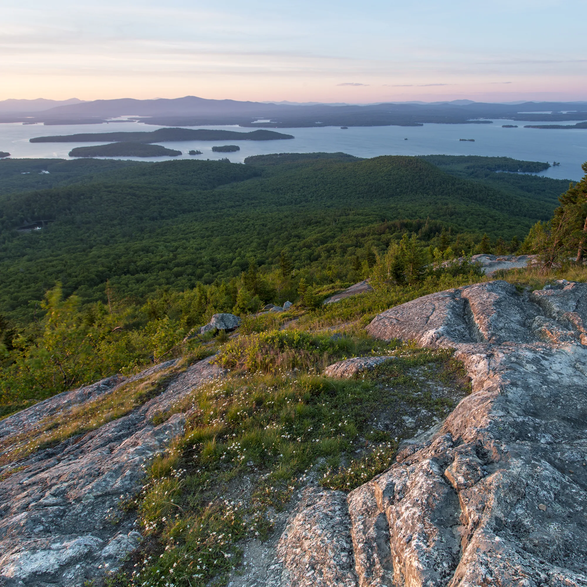 Overlooking a valley with a river running through it, with islands within it and a rocky mountain above