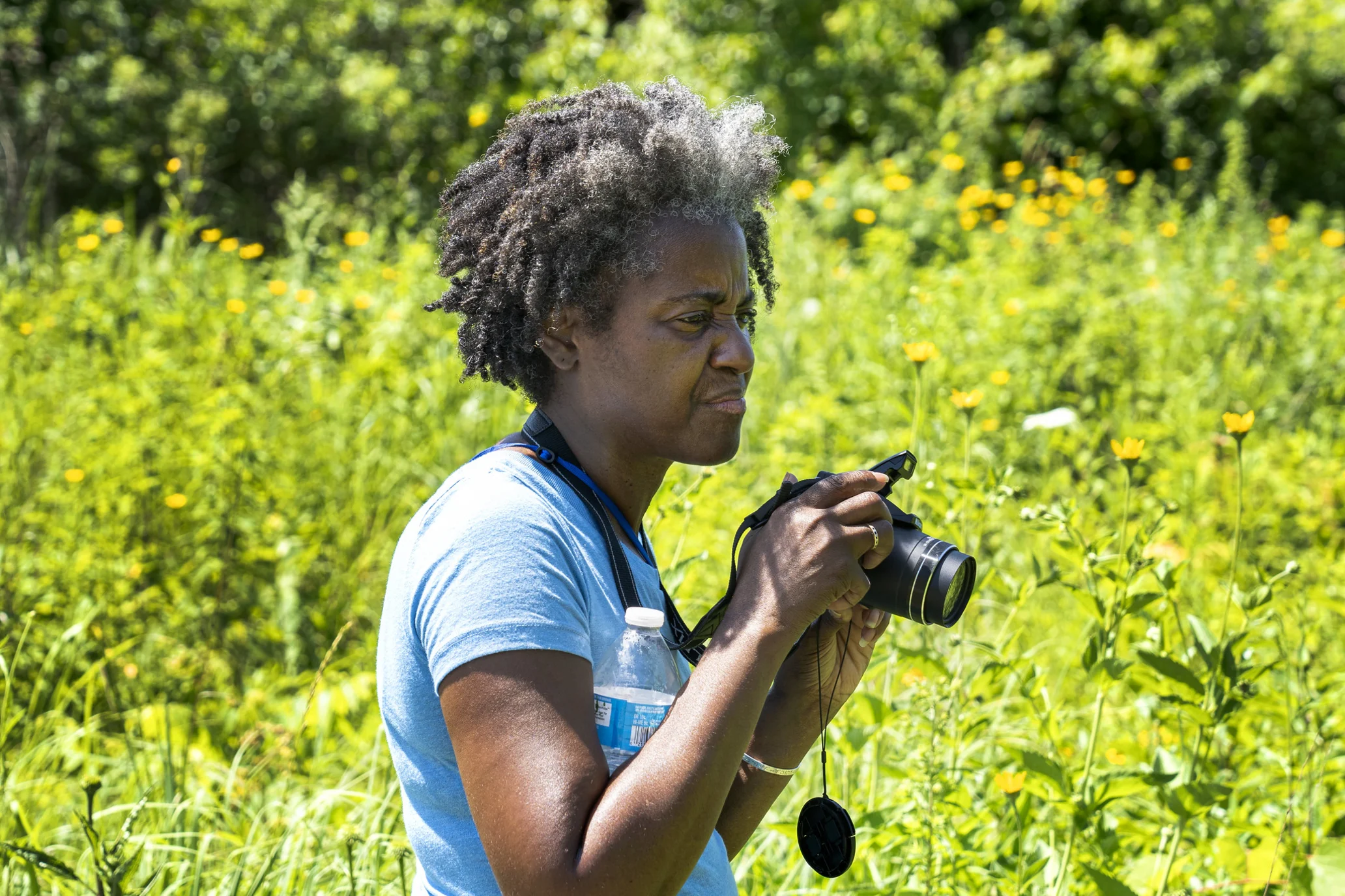 Woman holding a camera in nature.