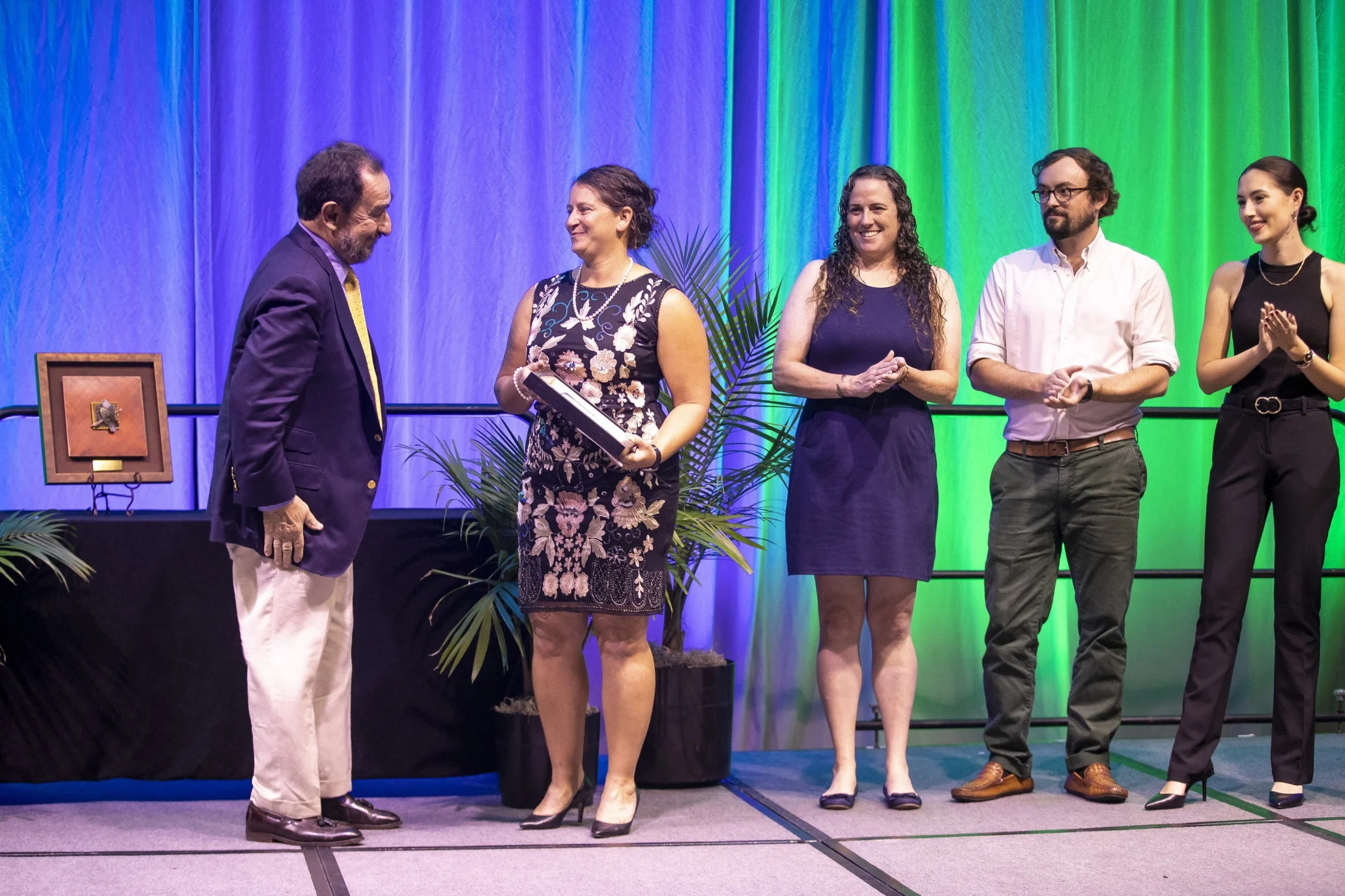 Three women and one man from Mount Grace Land Conservation Trust accept an award on stage for a member of the Land Trust Alliance board of directors.