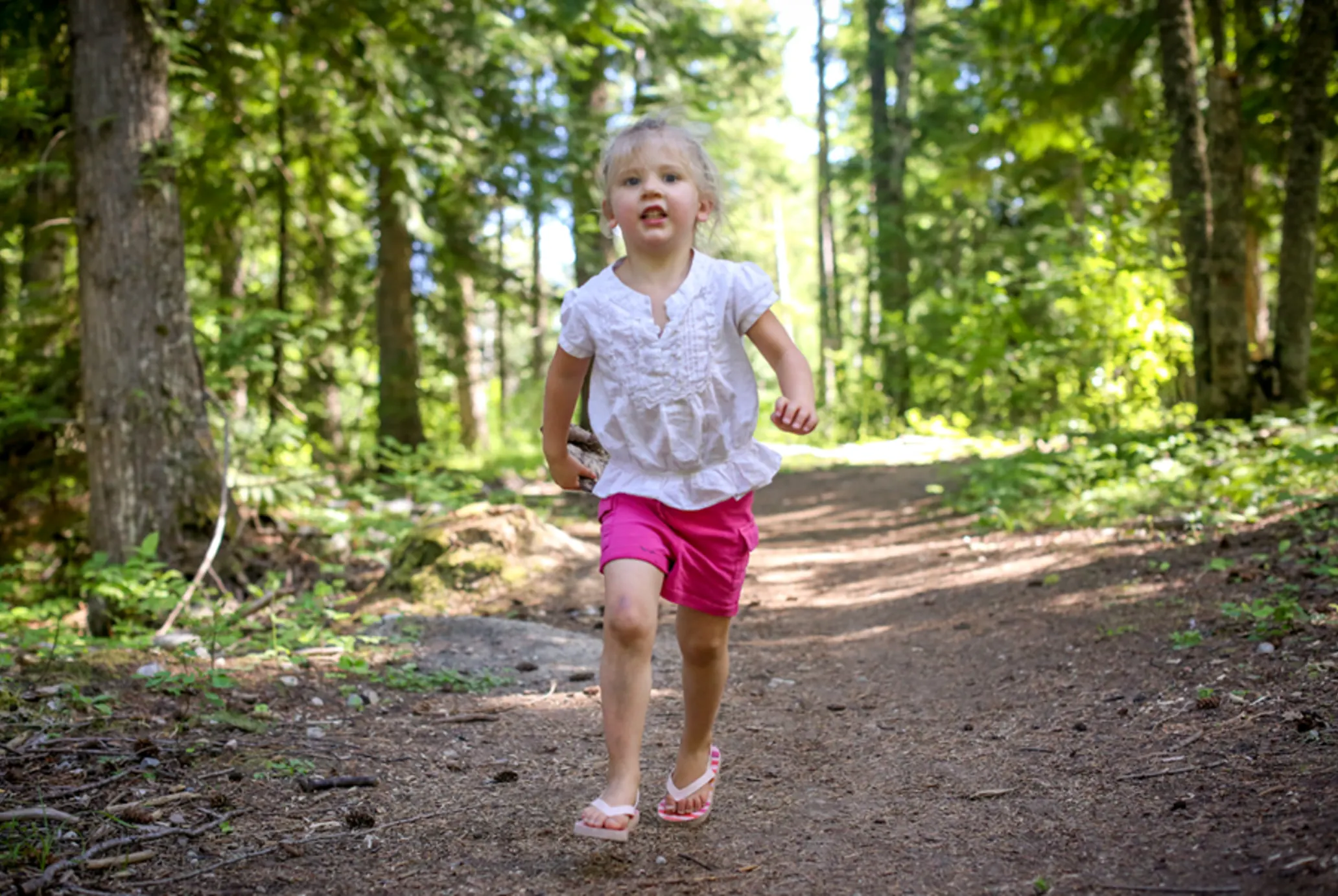 Little girl running down a dirt path.