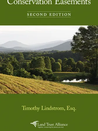 A green book cover featuring a forested landscape photo