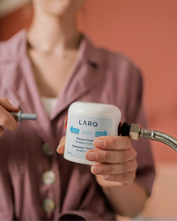 Person connect water line to LARQ Under Sink Water Filter