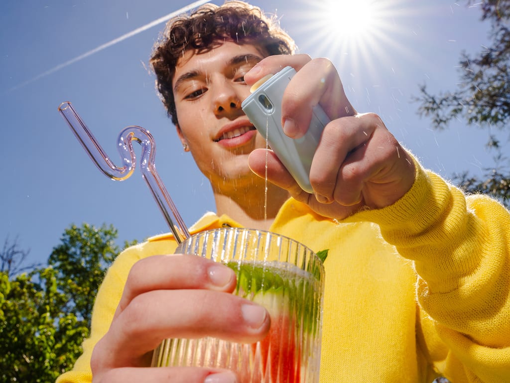 Man using the cūva Flavor Pod on a glass of water
