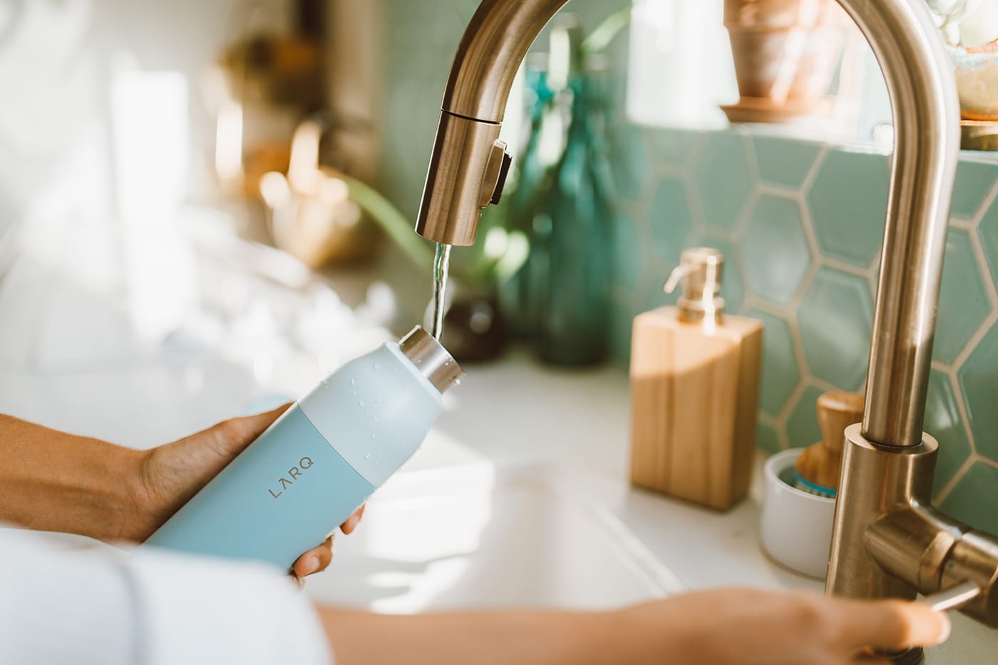 woman filling up LARQ Bottle in kitchen sink