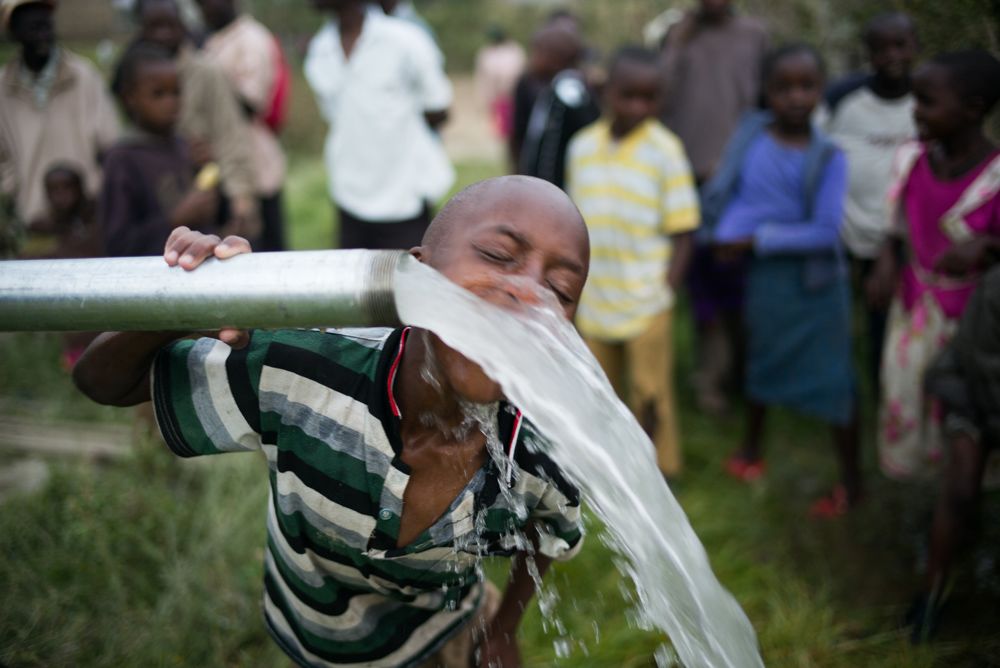 Boy in Ndabibi, Kenya drinking clean water from a newly built Well Aware Pump