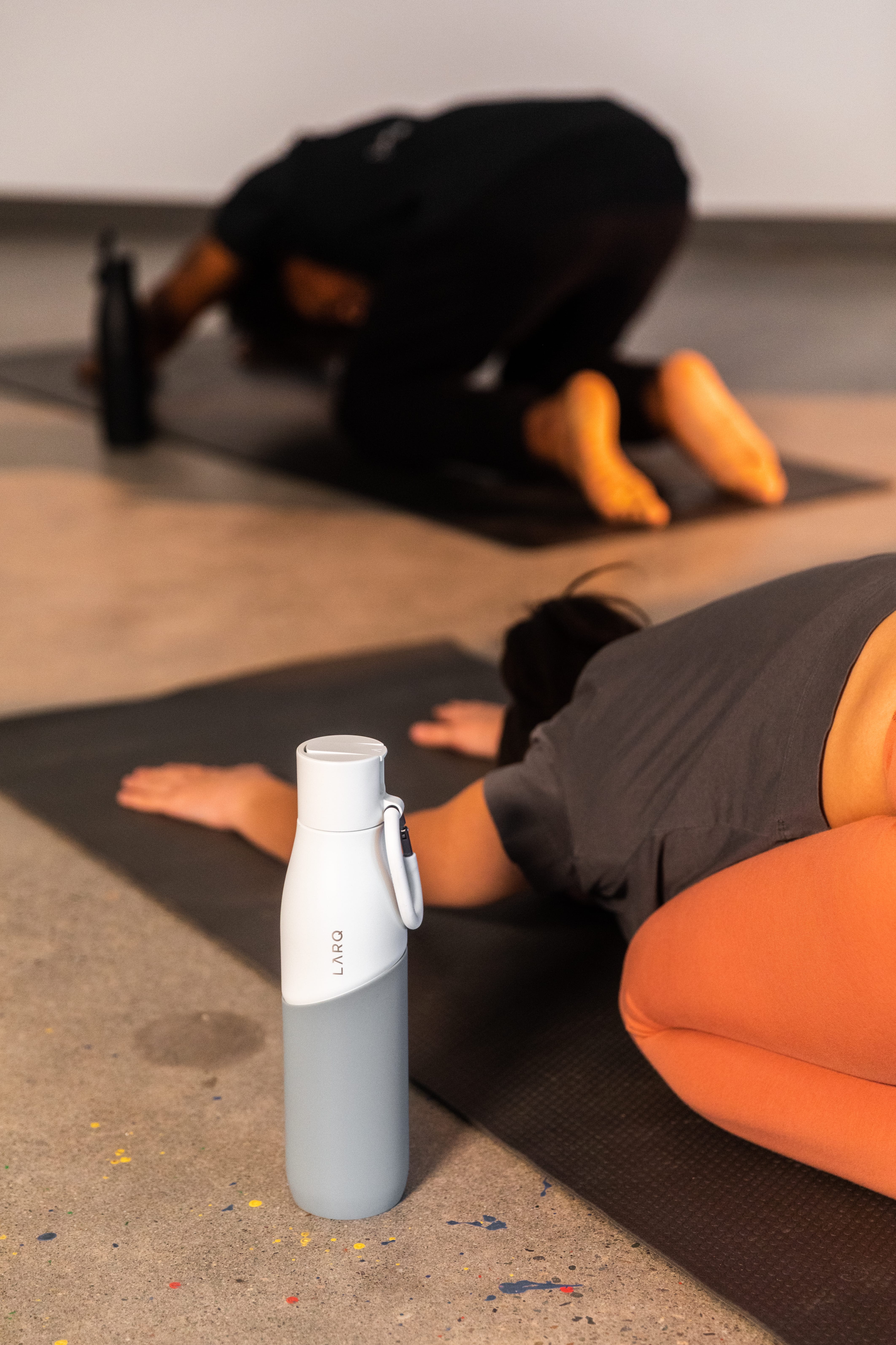 Woman doing yoga stretches next to her LARQ Bottle Movement Filtered