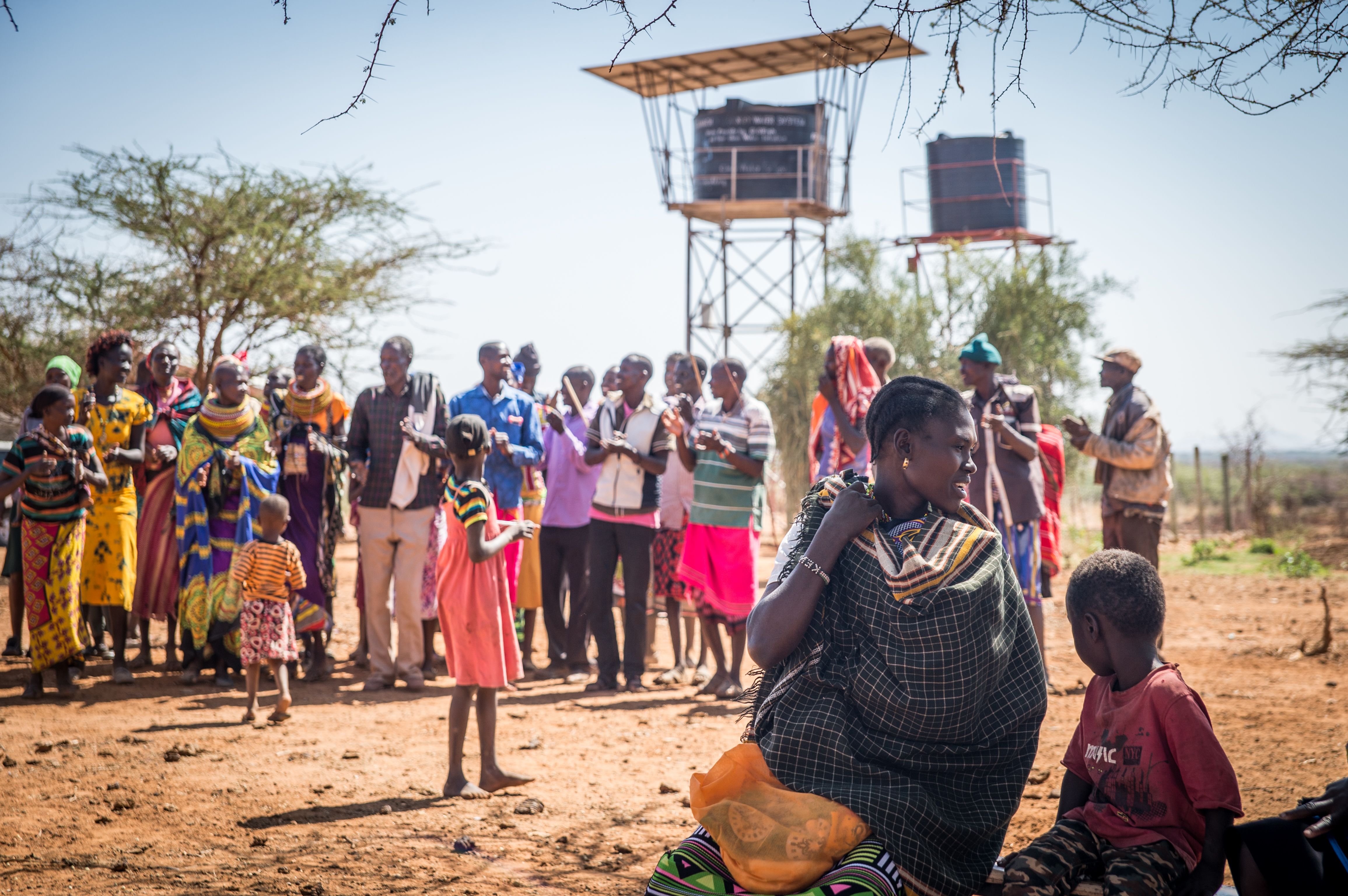 Community gathered around Well Aware water tanks - Alamach, Kenya