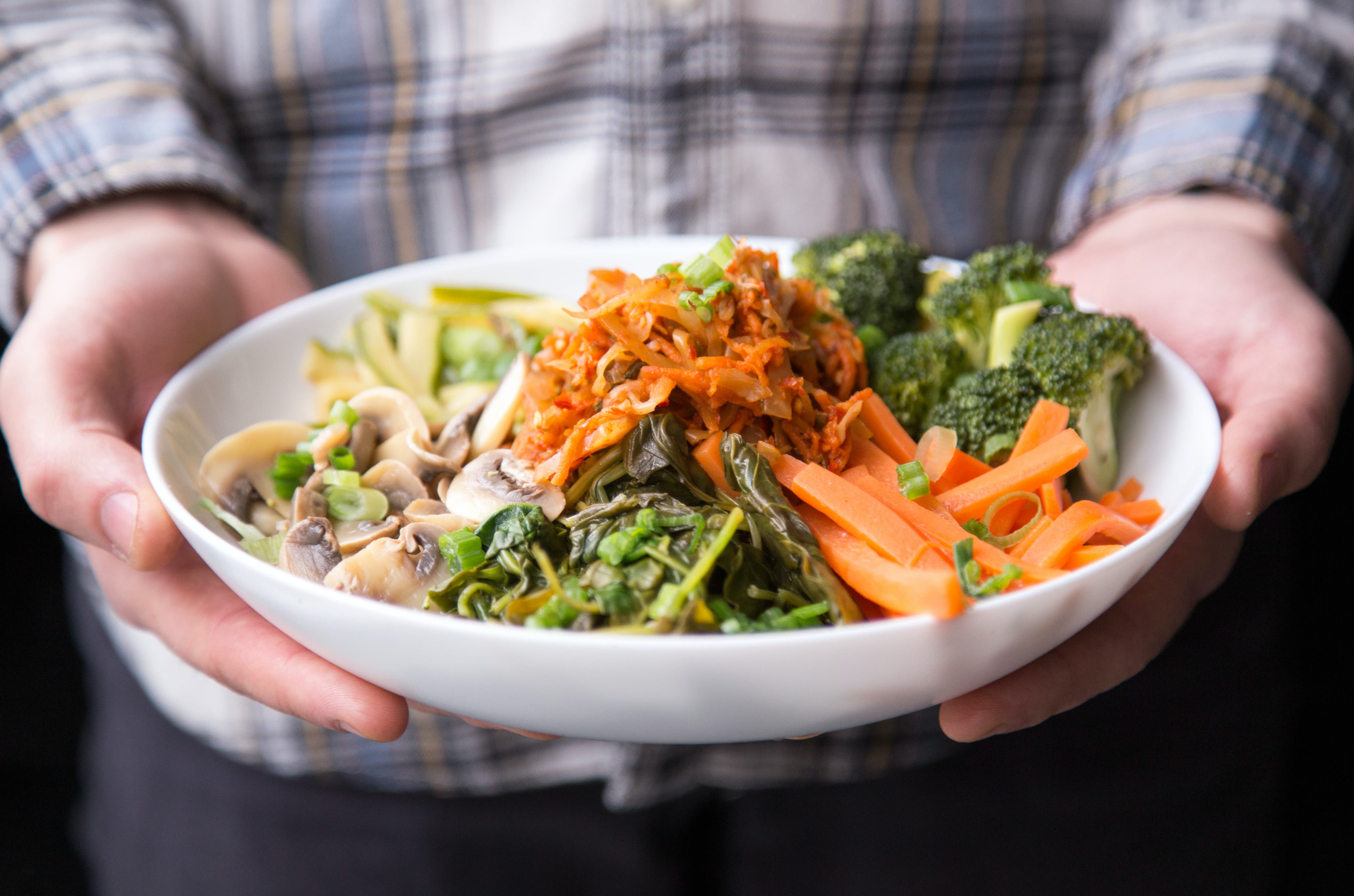 person holding plate of whole foods 